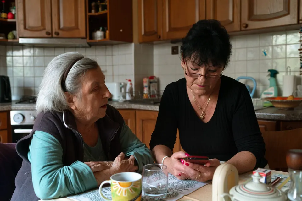 Deux femmes discutent à la table d'une cuisine, autour d'une tasse
